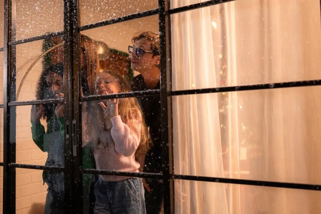 Parents and their teen daughter looking out into a snowy day.